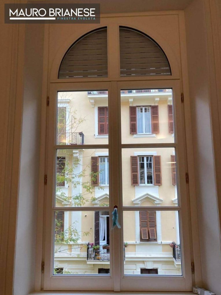 Finestra in stile classico, con un elegante design ad arco con dettagli architettonici distintivi.